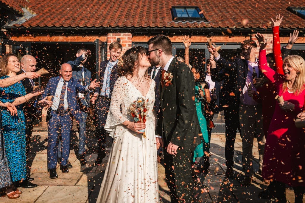 bride and groom kissing conffeti shot at thirsk barn lodges