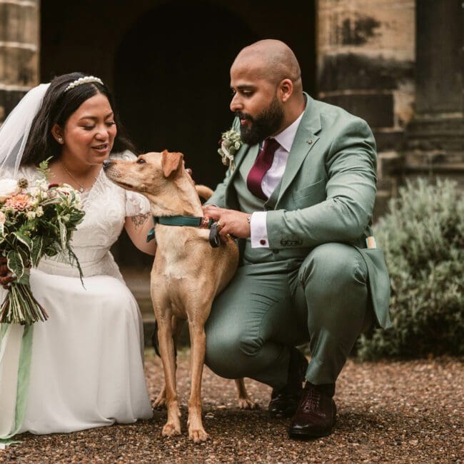 bride and groom and dog at east riddlesden hall - groom in green suit