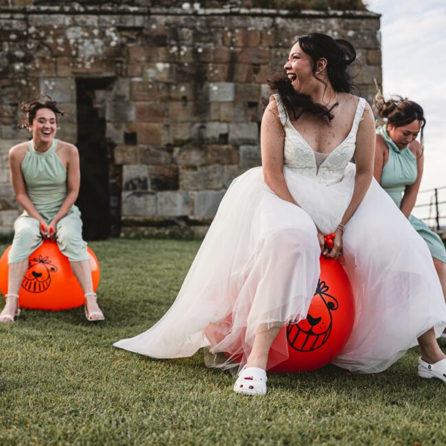 Bride on space hooper at danby castle with bridesmaids behind