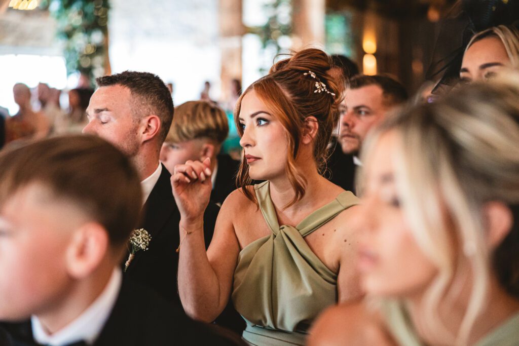 A guest rubbing away her tears as she watches her friends getting married