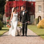 Bride & Groom and dog walking away from tissington hall | Yorkshire Wedding Photographer