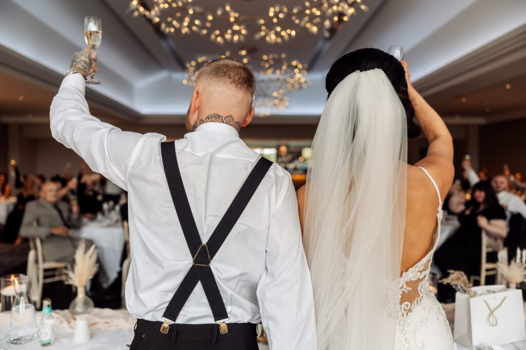 bride and groom toasting during speeches at crow wood hotel wedding